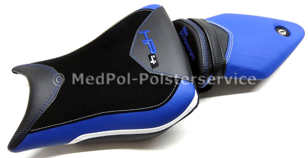 HP4 Fahrer & Soziussitz komplett Neubezug in Alcantara-S, Carbon, Blau, Weiß und Matt, mit Komfortpolsterung/Gel-Aktivmatte. Wechselseitige Ziernähte und doppelte Ziernaht in Weiß und Blau, Stickerei Blau + Gurtanfertigung