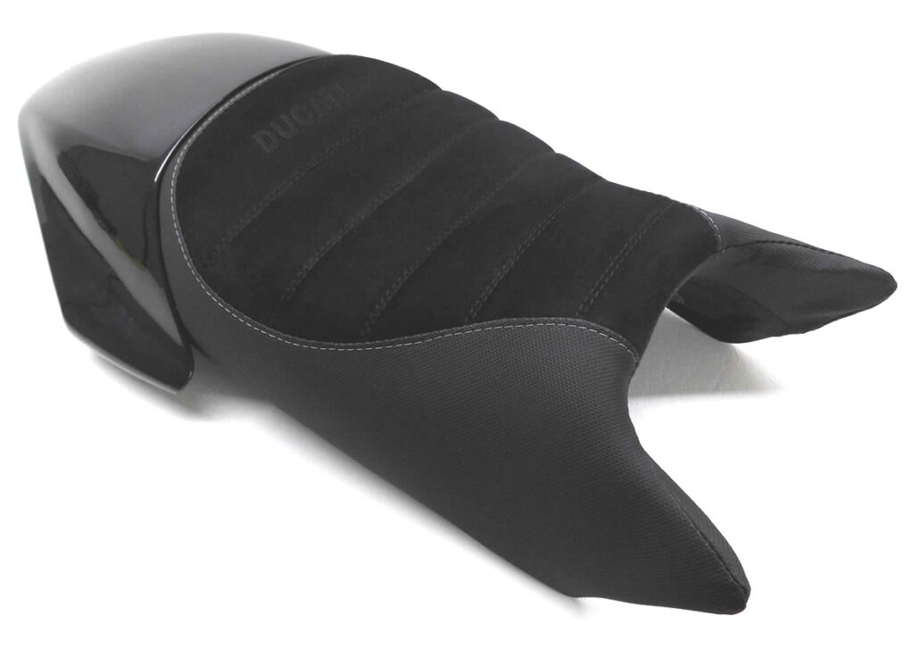 MONSTER 900 Kompletter Neubezug mit körperspezifischer Komfortpolsterung ⇒ Geleinlage. Den Fahrerbereich 2cm aufgepolstert und zum Tank hin höher gezogen. Materialmix: Alcantara und Antirutsch. Quersteppung mit doppelter Ziernaht in Schwarz sowie 1cm Polstereinzug, Ziernaht in Grau und Stick in Schwarz
